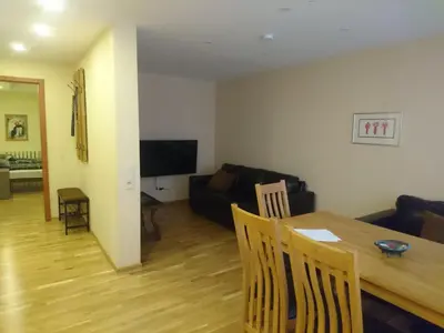 a living room with a table and a couch at Anyksciai nakvyne in Anykščiai