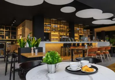 a table with a plate of food on it in a restaurant at Park Inn by Radisson Vilnius Airport Hotel & Conference Centre in Vilnius