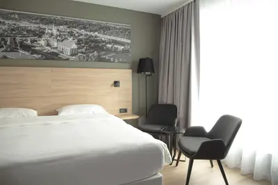 a hotel room with a bed and two chairs at Park Inn by Radisson Vilnius Airport Hotel & Conference Centre in Vilnius