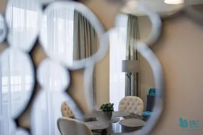 a dining room with a table and chairs and a mirror at Salt Apartments in Druskininkai
