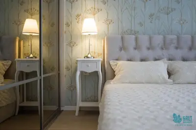 a bedroom with a white bed and two night stands at Salt Apartments in Druskininkai