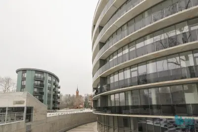 a large office building with a bridge in front of it at Salt Apartments in Druskininkai