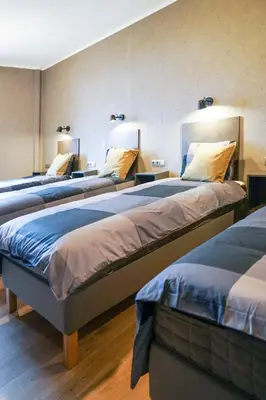 a group of three beds in a room at Timėjas in Ringaudai
