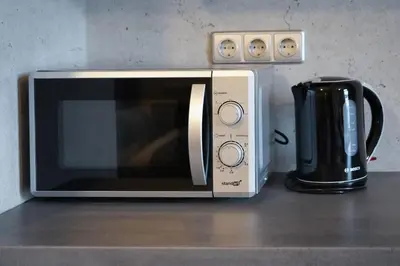 a microwave sitting on a counter next to a coffee maker at Timėjas in Ringaudai
