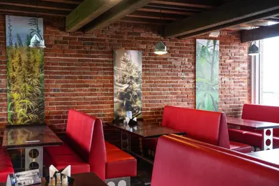 a restaurant with red chairs and a brick wall at Timėjas in Ringaudai