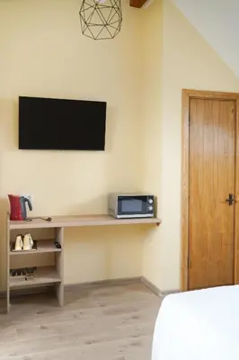 a room with a television on a wall with a bed at Timėjas in Ringaudai
