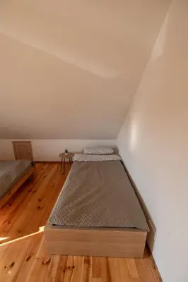 a small room with two beds in a attic at Sodyba 