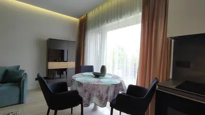 a living room with a table and chairs and a window at NEW J&R Apartment near Girstutis, Free private parking & Self Check-In in Kaunas
