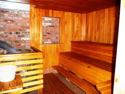 a sauna with wooden walls and wooden floors at Kurėnų Užeigos Svečių Namai in Kurėnai