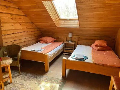 a bedroom with two beds in a log cabin at Kurėnų Užeigos Svečių Namai in Kurėnai