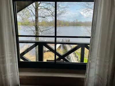 a window with a view of a lake from a house at Kurėnų Užeigos Svečių Namai in Kurėnai