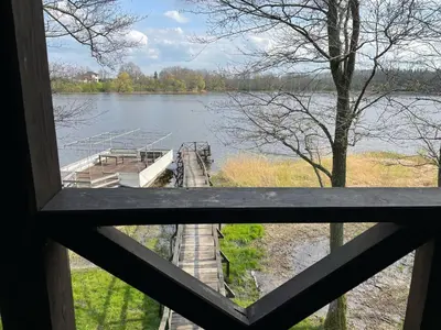 a view from a window of a bridge over a lake at Kurėnų Užeigos Svečių Namai in Kurėnai