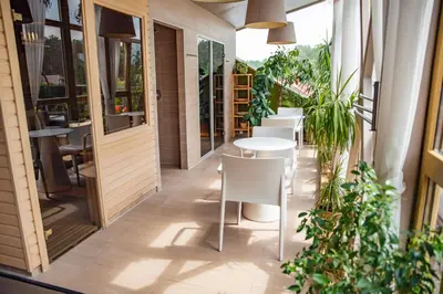 a restaurant with white tables and chairs and plants at Goda Hotel & Spa in Druskininkai
