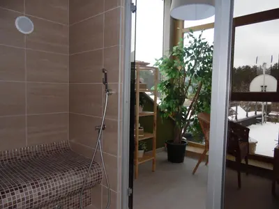 a bathroom with a shower with a bench in a room at Goda Hotel & Spa in Druskininkai