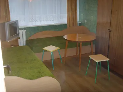 a small room with a table and two stools at Chernobyl type rooms in a block flat house in Šiauliai