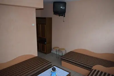 a room with two beds and a tv on the wall at Chernobyl type rooms in a block flat house in Šiauliai