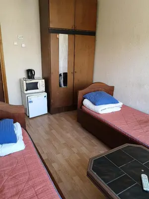 a small room with two beds and a kitchen at Chernobyl type rooms in a block flat house in Šiauliai