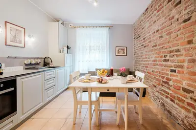 a kitchen with a table and a brick wall at Editas apartament in Kaunas