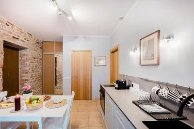 a kitchen with a white counter top and a table at Editas apartament in Kaunas