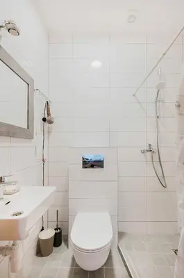 a white bathroom with a toilet and a sink at Editas apartament in Kaunas
