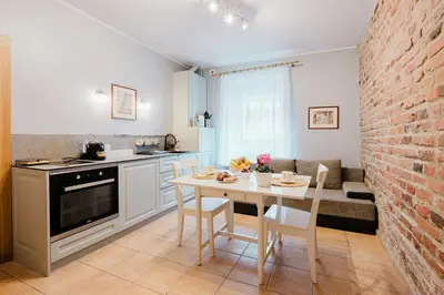 a kitchen and dining room with a table and a brick wall at Editas apartament in Kaunas