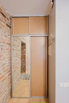 a glass door in a room with a brick wall at Editas apartament in Kaunas