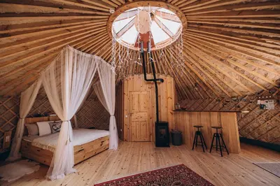 a bedroom with a bed in a yurt with a window at VasaRojaus Jurta in Birštonas