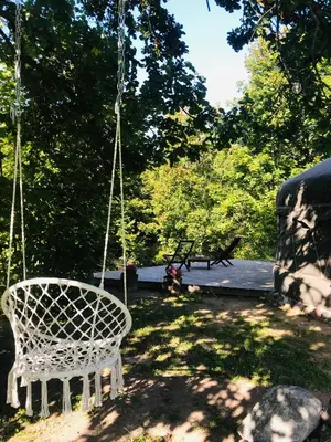 a white swing in a yard with a bench at VasaRojaus Jurta in Birštonas