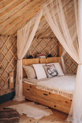 a bedroom with a bed in a wooden ceiling at VasaRojaus Jurta in Birštonas