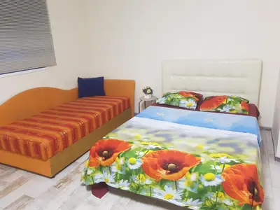 a bedroom with a bed and a poppy bedspread at Studio by the Lake Kaunas in Kaunas