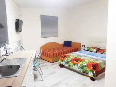 a bathroom with a bed and a sink in a room at Studio by the Lake Kaunas in Kaunas