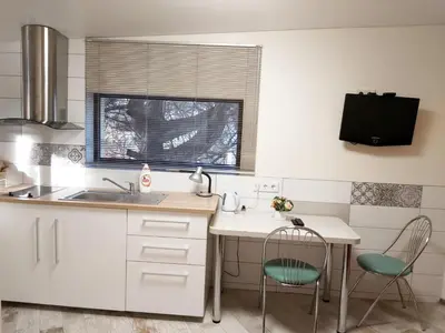 a kitchen with a sink and a table and chairs at Studio by the Lake Kaunas in Kaunas