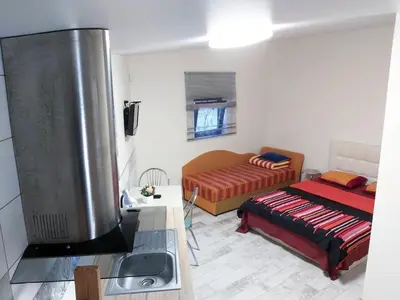 a living room with a tv and a bed at Studio by the Lake Kaunas in Kaunas