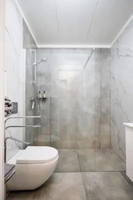 a bathroom with a shower with a toilet and a sink at Owls Hill Apartment in Kaunas