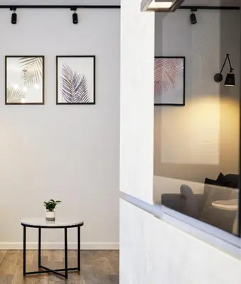 a table in a room with four pictures on the wall at Owls Hill Apartment in Kaunas
