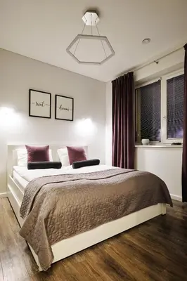 a bedroom with a large bed and a window at Owls Hill Apartment in Kaunas