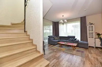a living room with a staircase and a couch at Druskininkų Šlaitas in Druskininkai