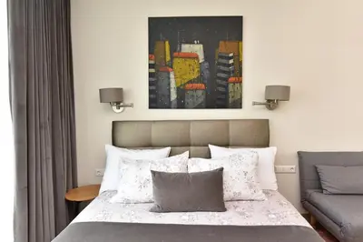 a bedroom with a bed and a painting on the wall at Druskininkų Šlaitas in Druskininkai