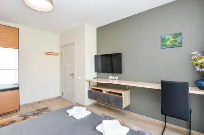 a living room with a desk and a tv at Druskininkų Šlaitas in Druskininkai