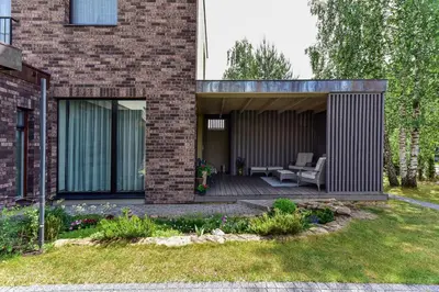 a brick house with a deck and a patio at Druskininkų Šlaitas in Druskininkai
