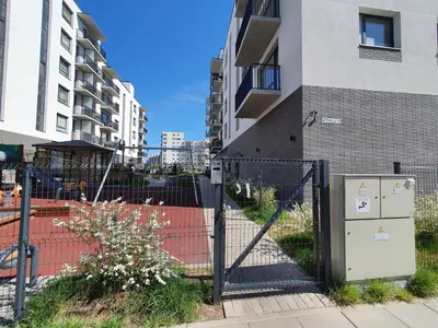 a fence in front of a building next to a building at Bitenu Studio in Vilnius
