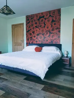 a bedroom with a large bed with a painting of roses at Irene apartments in Druskininkai