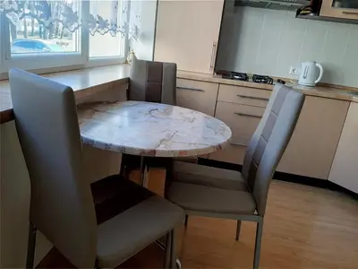 a table and chairs in a kitchen with a marble table at Irene apartments in Druskininkai