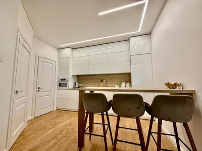 a kitchen with two bar stools and a counter at Varpo 17 in Šiauliai