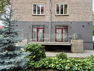 a house with a balcony in front of a building at Varpo 17 in Šiauliai