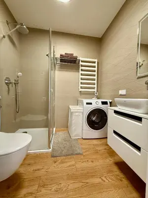 a bathroom with a washing machine and a sink at Varpo 17 in Šiauliai