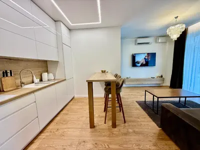 a kitchen with white cabinets and a table at Varpo 17 in Šiauliai