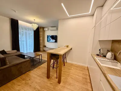 a kitchen and living room with a table and a couch at Varpo 17 in Šiauliai