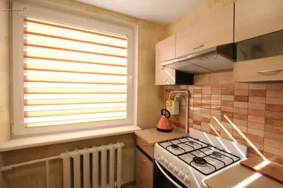 a kitchen with a stove and a window at Lukšio Apartment in Šiauliai
