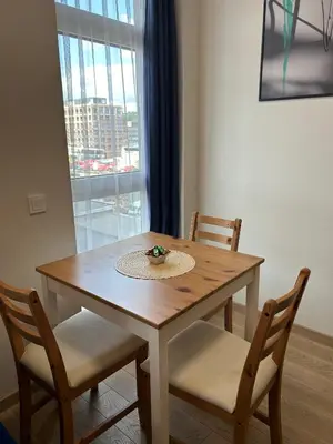 a wooden table with two chairs and a window at Your Home - Stylish Studio Apartment in Center, with Balcony & Self Check-in in Vilnius
